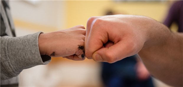„Ich kann wenigstens beim Papa sein“ Ein Insasse gibt in der Vater-Kind-Gruppe in der JVA Nürnberg seinem Sohn einen Fist Bump.