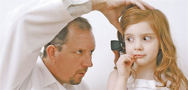 Pädiater sehen keine Überversorgung Ein Kinderarzt untersucht eine junge Patientin mit Ohrenschmerzen.