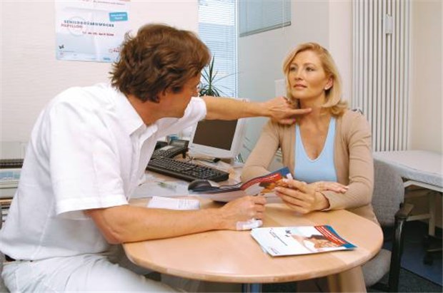 Palpation der Schilddrüse - bundesweit ab 21. April Ein Kollege erklärt einer Patientin den Schlucktest zur Früherkennung von Schilddrüsenkrankheiten.