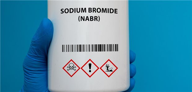 Eine Plastikdose mit Natriumbromid (NaBr) und den zugehörigen Warnsymbolen.