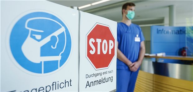 Versorgung von Krebspatienten leidet durch die Corona-Pandemie Ein Mitarbeiter am Eingang des Universitätsklinikums Heidelberg Ende April: Die Auswirkungen auf die onkologische Versorgung sind schwer einzuschätzen.