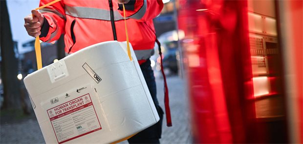 Ein Mitarbeiter der Malteser stellt eine Kühlbox für eine Organspende in einen Transporter. (gestellte Szene)