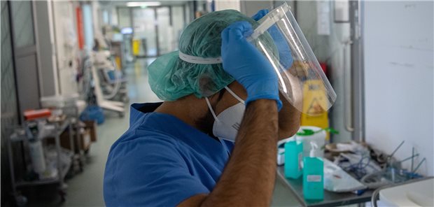 Pflegekammer Rheinland-Pfalz: Einstiegsgehalt 4000 Euro? Ein Pfleger zieht auf der Intensivstation für Corona-Patienten beim Verlassen der Station sein Visier aus. Die Pandemie hat die Arbeitsbelastung bei den Pflegekräften erhöht, aber viele Probleme – so auch der Fachkräftemangel – waren schon vor der Pandemie bekannt. (Archivbild)