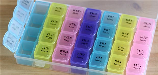Wöchentliche Pillenbox mit verschiedenen Pillen für die tägliche Medikation.