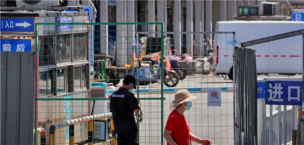 China: Angst vor neuer Virus-Welle Ein Wachmann verschließt mit einer Kette den Zaun des Haupteingangs des Meeresfrüchte-Großmarkts, der für Inspektionen geschlossen wurde.