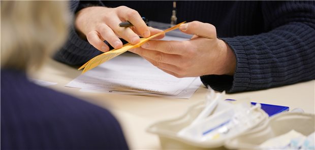 Corona-Impfpolitik: Saar-Praxen sehen sich benachteiligt EinArzt füllt nach der Corona-Impfung einen Impfpass aus. Die Nachfrage nach der Impfung lässt im Saarland aktuell schon wieder nach.