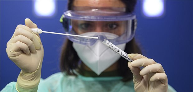 Eine Ärztin der Kassenärztlichen Vereinigung Sachsen hält in der Corona-Teststation für Urlaubsrückkehrer am Flughafen Dresden International einen Coronavirus-Test in den Händen (Archivbild). Laborärzte des Berufsverbands BDL fordern kostenlose PCR-Tests für Reiserückkehrer aus Risikogebieten auch in diesem Sommer.