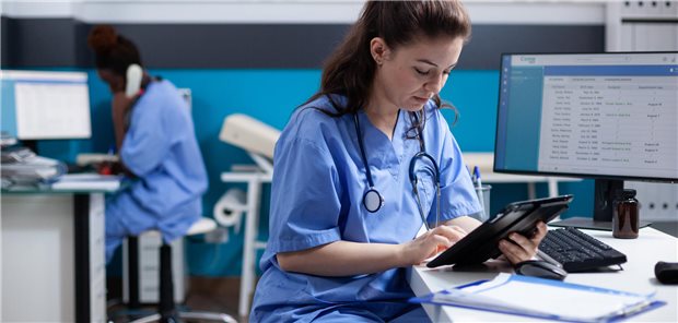 Eine Ärztin pflegt Daten in ein Krankenhausinformationssystem ein.