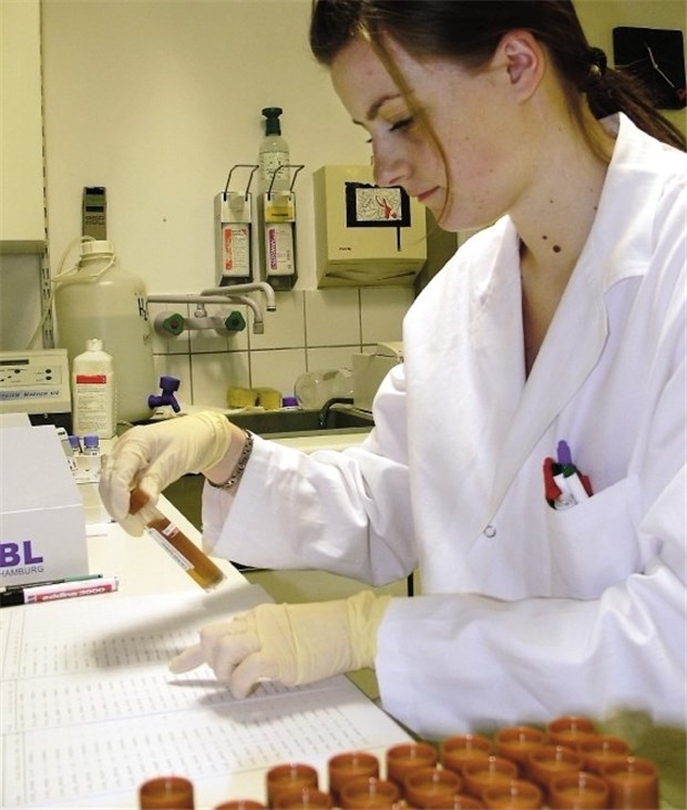 Tests - eine Säule der Vorsorge Eine Assistentin sortiert nach einer Arbeitsliste Stuhlproben für die Analyse. Regelmäßige Stuhltests sind beim Darmkrebs-Screening unerlässlich.