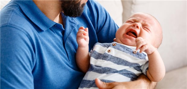 Säugling auf dem Arm seines Vaters