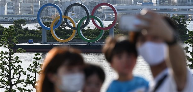 Eine Familie macht vor den Olympischen Ringen ein Selfie. In der Bevölkerung wachsen mit den steigenden Neuinfektionen die Sorgen vor einer Überlastung des Gesundheitswesens.