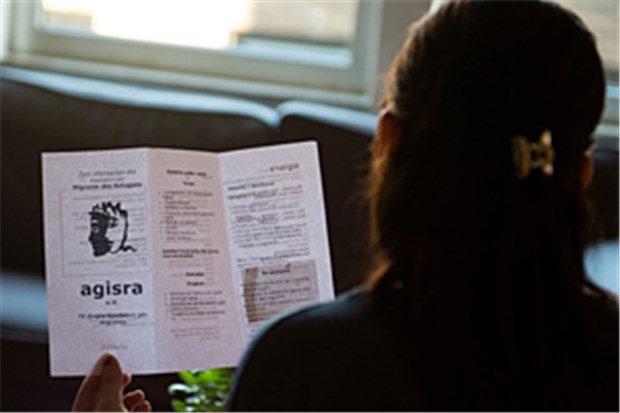 Das sind die Gewinner! Eine Flüchtlingsfrau aus Albanien mit einem Flyer der Kölner Frauen-Hilfsorganisation agisra.