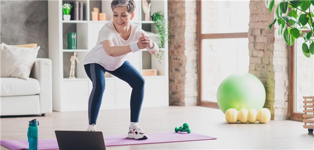 Eine Frau beim Sport vor ihrem Laptop.
