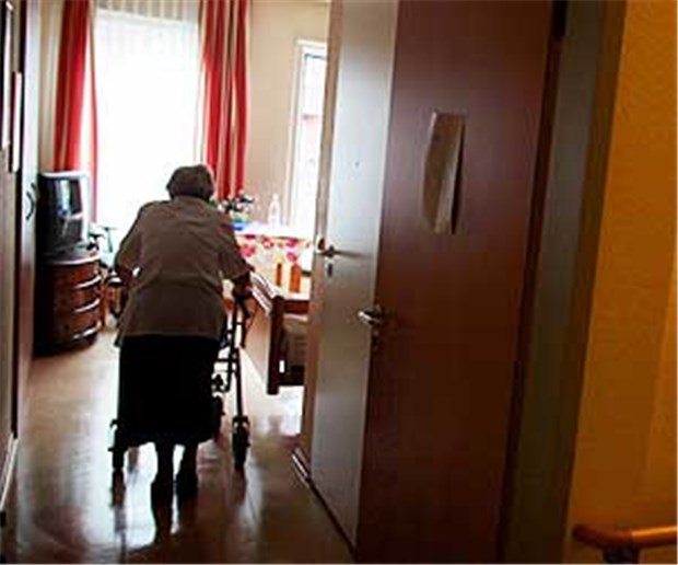 Hunderte Pflegeheime vor der Insolvenz Eine Frau geht in einem Altenheim mit ihrem Rollator in ihr Zimmer. Viele Pflegeheime stehen angeblich vor der Insolvenz.
