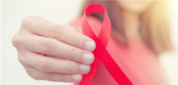 Eine Frau hält die Rote Schleife, Symbol der Solidarität mit HIV-Infizierten. In Deutschland leben rund 17000 HIV-infizierte Frauen.