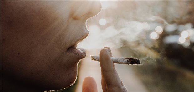 Eine Frau raucht einen Marihuana-Joint: Starker Konsum könnte CB-1-Rezeptoren aktivieren, die zu Vasokonstriktion und endothelialer Dysfunktion beitragen.