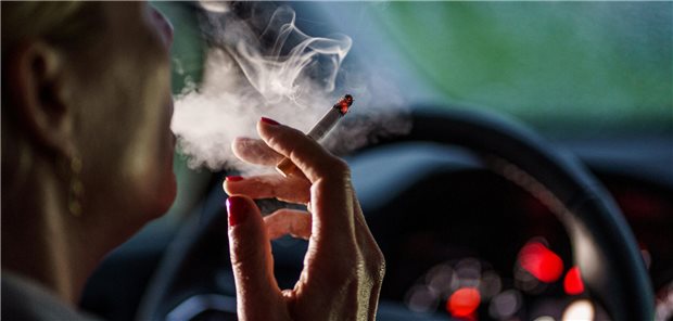 Koalition begräbt die Pläne für ein Rauchverbot im Auto Eine Frau sitzt mit einer brennenden Zigarette hinter dem Lenkrad ihres Autos (Symbolbild mit Fotomodell): Die Schadstoffkonzentrationen beim Rauchen im Auto sind besonders hoch, weil der Raum so klein ist.