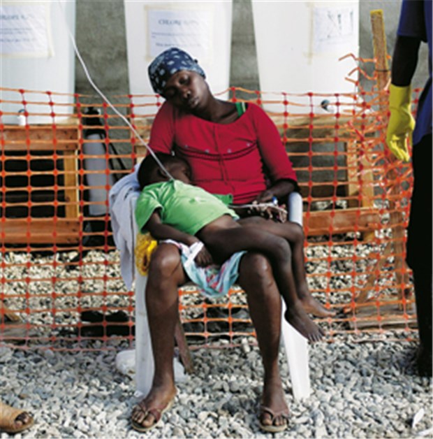 Haiti: Liegen Cholera-Kranke bald im Freien? Eine Frau und ein Kind, beide mit Cholera-Symptomen, werden vor einer Klinik im Armenviertel Cité Soleil in Port-au-Prince versorgt.
