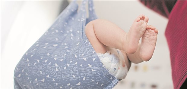 Eine Hebamme wiegt im Rahmen der Nachsorge ein Baby: Die Ausbildungsreform in Baden-Württemberg erweist sich in der Umsetzung als herausfordernd.