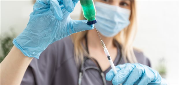 Eine Impfdosis wird aufgezogen: Weil in Deutschland weiterhin die Omikron-Variante von SARS-CoV-2 dominiert, sollten auch die entsprechenden Variantenimpfstoffe verwendet werden (Symbolbild mit Fotomodell).