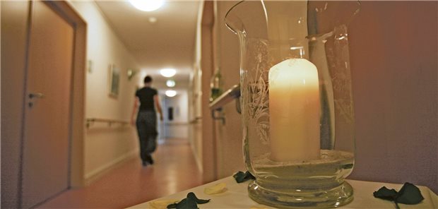 Eine Kerze steht auf einem Tisch in einem Gang des Christophorus Hospiz in München vor dem Zimmer eines gestorbenen Bewohners. Die Gießener Sterbestudie gibt Hinweise auf große Qualitätsunterschiede in der Begleitung Sterbender