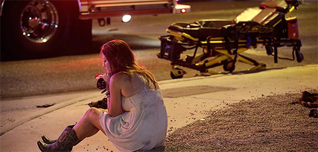 Schütze tötet 50 Menschen in Las Vegas Eine Konzertbesucherin sitzt nach dem Amoklauf in Las Vegas nahe des Mandalay Bay Resort und Casinos am Las Vegas Strip.