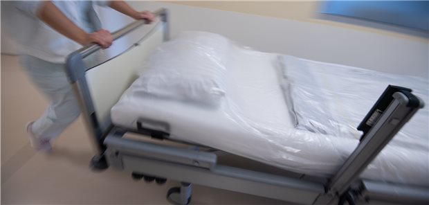 Zahl der Intensivbetten in Kliniken stark gestiegen Eine Krankenpflegerin schiebt ein Krankenbett durch einen Gang einer Station: Die Gesamtzahl der Betten geht in Deutschland seit Jahren zurück.