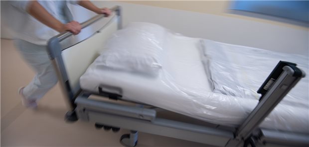 Eine Krankenpflegerin schiebt ein Krankenbett durch einen Gang einer Station. Die Beteiligung des Bundesfinanzministeriums bei der Verordnung über die Pflegepersonalbemessung im Krankenhaus stößt in den Ländern auf Kritik.