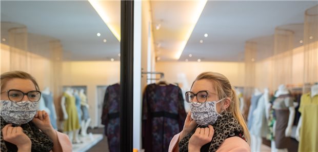 Maskenpflicht in drei Bundesländern Eine Kundin betrachtet in einem Dresdner Geschäft ihren neuen Mundschutz in einem Spiegel.