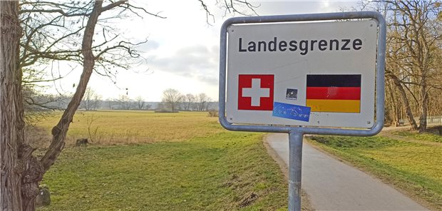 Landesgrenze zwischen Schweiz und Deutschland: Schild vor einem schmalen Weg zwischen Wiesen und Bäumen