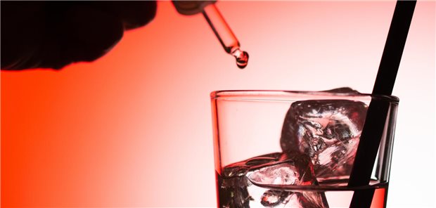 Giftattacke in der Rettungswache? Junge Sanitäterin in Haft Eine Person träufelt etwas in ein Glas.