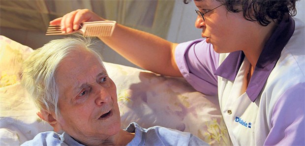 Häusliche Pflege ist günstiger Eine Pflegekraft kümmert sich um eine Demenzpatientin. Für Angehörige ist die Pflege oft belastend.