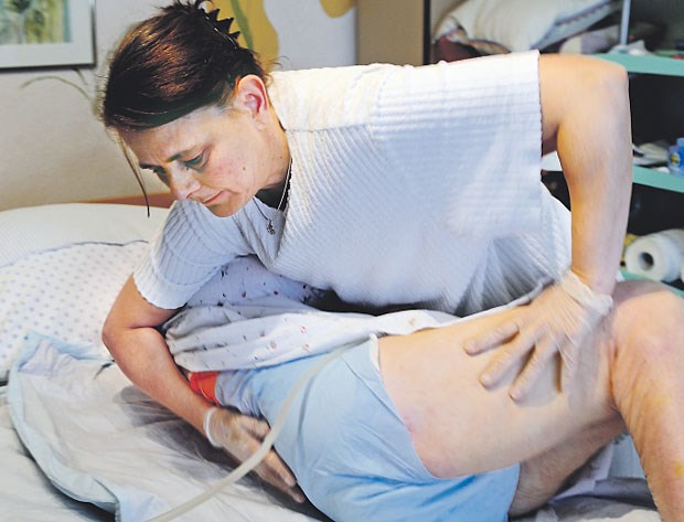 Bessere Heimversorgung - mehr Geld für Ärzte? Eine Pflegerin bettet ihren Patienten um. Die Gesundheitspolitiker der Unionsfraktion haben Vorschläge zur Pflegereform unterbreitet.