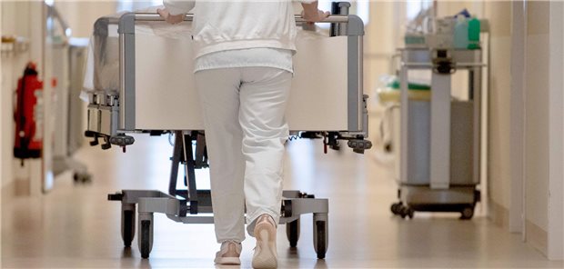 Studie: Warkens GKV-Gesetz bringt Krankenhäuser in Konkursgefahr Pflegeperson schiebt Krankenhausbett über den Krankenhausflur.