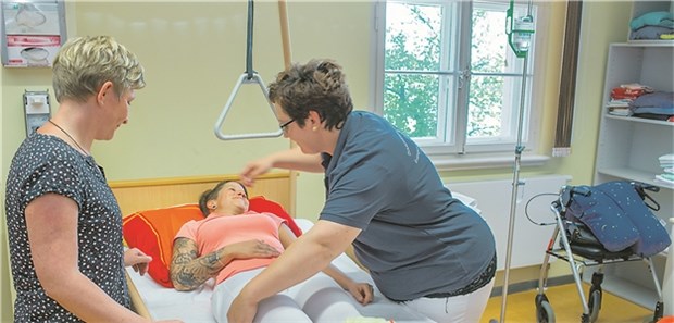 Länderkammer stimmt Pflegeberufegesetz ohne Begeisterung zu Eine Pflegeschülerin übt in einer Altenpflegeschule an einer Mitschülerin das Drehen einer Person im Bett.