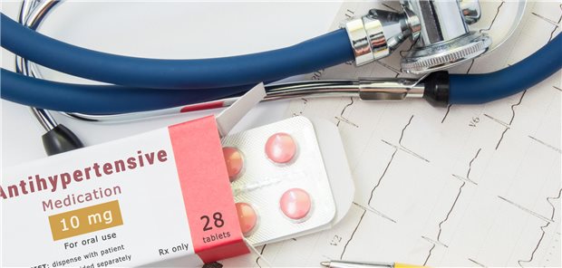 Eine Medikamentenverpackung mit der Aufschrift "Antihypertensive Medication" liegt neben einem Stethoskop. 