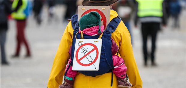 Experten: Corona-Krise könnte Impfbereitschaft fördern Eine Teilnehmerin einer Protestkundgebung der Initiative „Querdenken“ trägt auf dem Cannstatter Wasen in Stuttgart ein Schild gegen Impfungen auf ihrem Rücken.