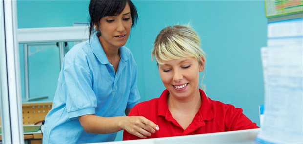 Frau hilft anderer am Pc.