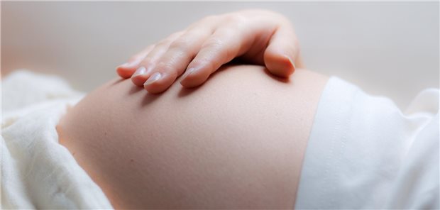 Bauch einer schwangeren, sie legt ihre Hand darauf.