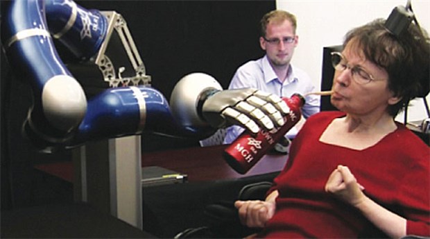 Nach Schlaganfall: Kaffeetrinken trotz Lähmung Eine vom Hals abwärts gelähmte Frau trinkt Kaffee aus einem Becher mittels eines Robotorarms, den sie mit ihren Gedanken steuert.