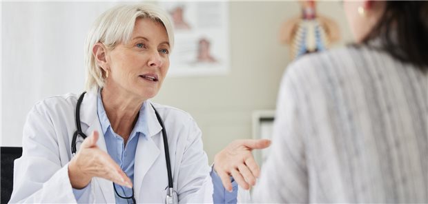 Eine Ärztin und eine Patientin bei einer Konsultation in der Klinik über Gesundheitszustand und Wellness.