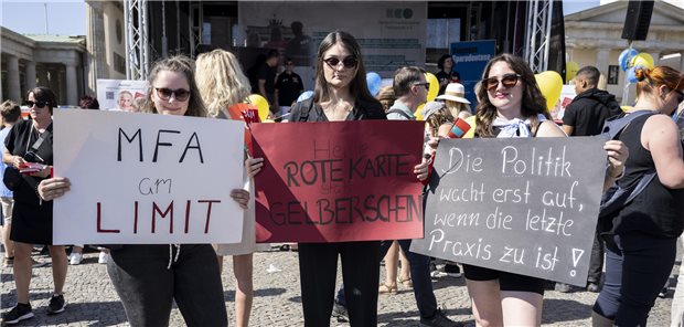 MFA halten Protestschilder in die Luft