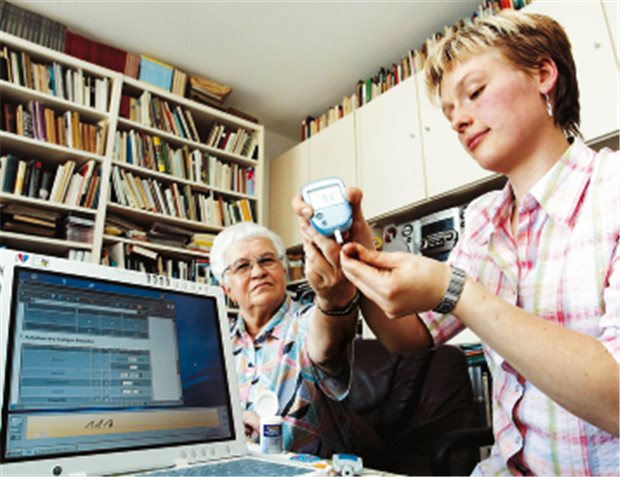 Einsatz auf Rügen: Tele-Gesundheitsschwester misst bei Hausbesuch den Blutzucker einer Patientin.