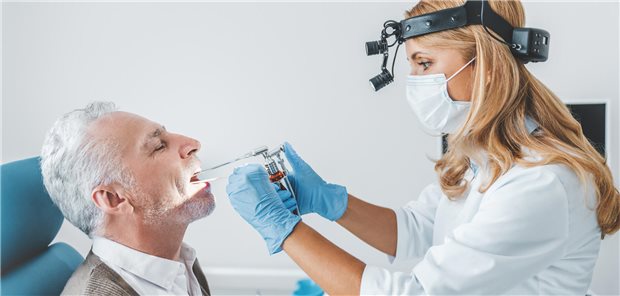 Endoskopische Untersuchung der Mundhöhle eines älteren Patienten. (Symbolbild mit Fotomodellen)