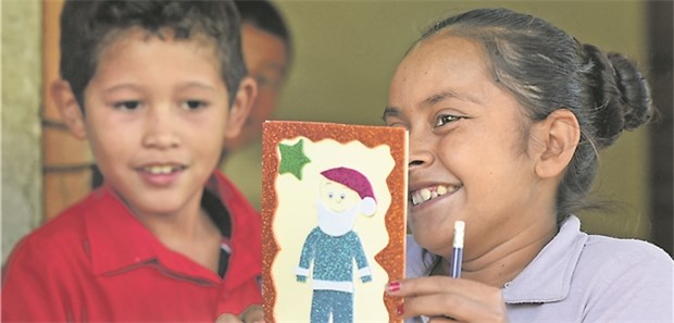 Kinderpatenschaft für eine bessere Welt Enma aus Nicaragua zeigt ihre Weihnachtskarte, die sie für ihre Patin Ursula aus Deutschland gestaltet hat.