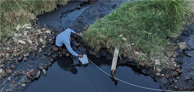 Studie: Nicht nachhaltige Produktionsbedingungen führen zu mehr Antibiotikaresistenzen Entnahme einer Umweltwasserprobe aus einem schwarzen Gewässer unterhalb des Oberflächenwasserablaufs einer Produktionsstätte für Antibiotika.
