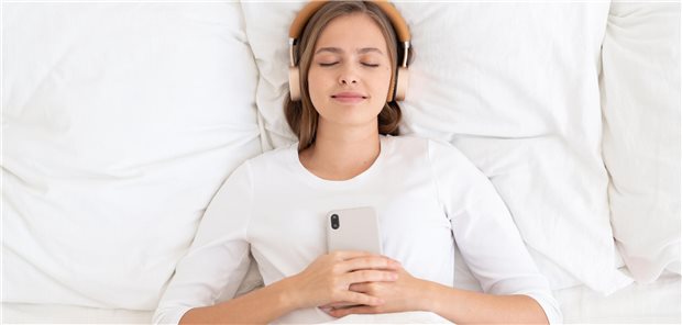 Schlafende Frau, die etwas über Kopfhörer hört