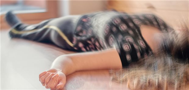 Eine Frau liegt auf dem Boden und hat einen epileptischen Anfall. Das Bild ist verwackelt.