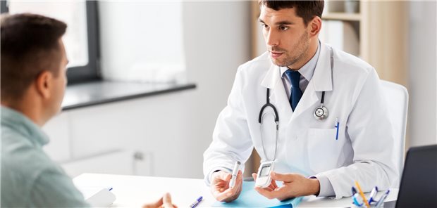 Arzt im Gespräch mit Patient in seiner Praxis.