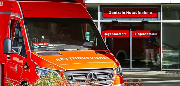 Zentrale Notaufnahme des Universitätskrankenhauses in Düsseldorf mit einem rotem Rettungswagen vor dem Eingang.